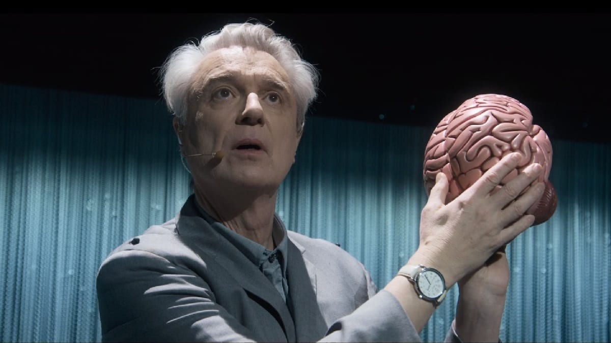 David Byrne, the creative mind behind the musical American Utopia, performing his musical while holding a plastic brain. Byrne is best known for his work within the band Talking Heads. Photo credits: David Byrnes American Utopia on Max.